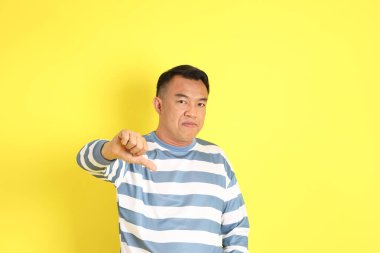 The 40s adult Asian man with standing on the yellow background.
