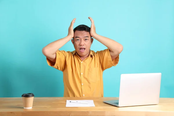 40S Adult Asian Man Yellow Shirt Sitting Desk Blue Background — Stock Photo, Image