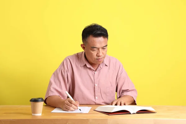 40Άρης Ασιάτης Άνδρας Ροζ Πουκάμισο Κάθεται Στο Γραφείο Κίτρινο Φόντο — Φωτογραφία Αρχείου