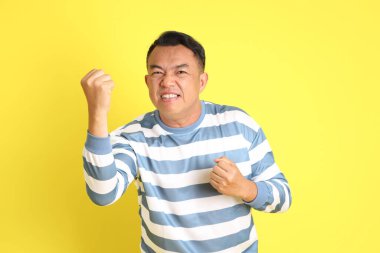 The 40s adult Asian man with standing on the yellow background.