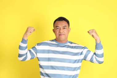 The 40s adult Asian man with standing on the yellow background.