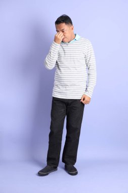 The 40s adult Asian man with standing on the purple background.