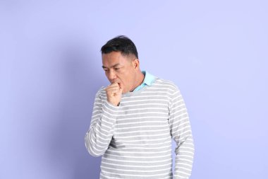 The 40s adult Asian man with standing on the purple background.