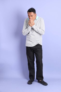 The 40s adult Asian man with standing on the purple background.