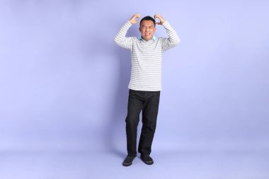 The 40s adult Asian man with standing on the purple background.