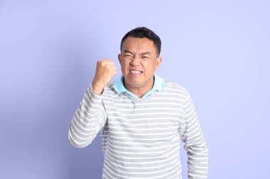 The 40s adult Asian man with standing on the purple background.