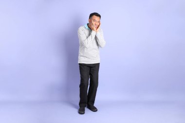 The 40s adult Asian man with standing on the purple background.