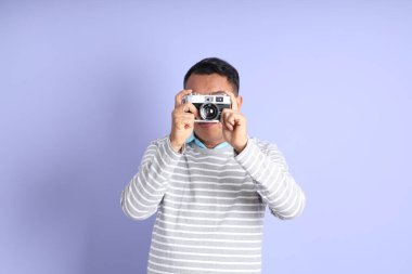 The 40s adult Asian man with standing on the purple background.