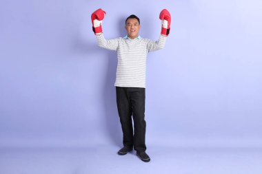 The 40s adult Asian man with standing on the purple background.