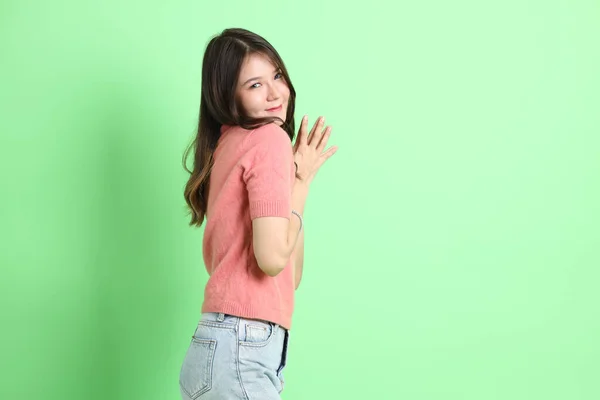 Молодая Взрослая Азиатка Повседневной Одежде Джинсах Стоящая Зеленом Фоне — стоковое фото