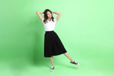 Yeşil arka planda duran üniformalı genç kız..