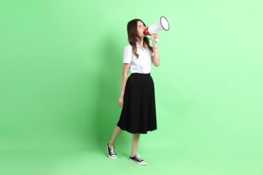 Yeşil arka planda duran üniformalı genç kız..