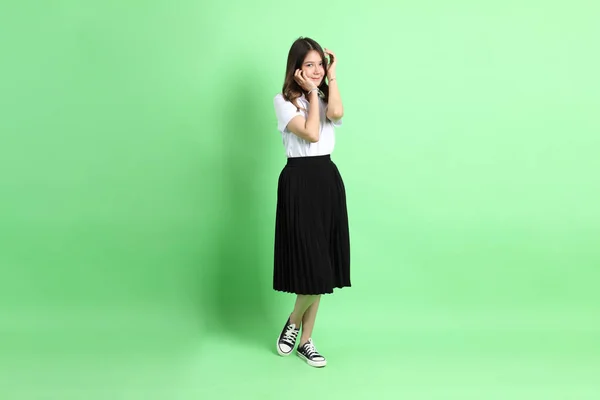 緑の背景に制服を着た若い女の子 — ストック写真