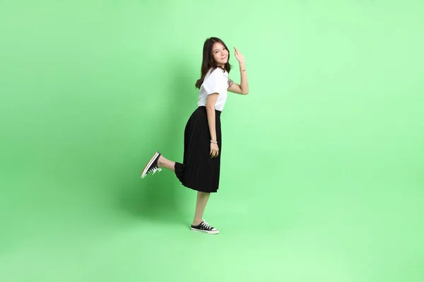 Yeşil Arka Planda Duran Üniformalı Genç Kız — Stok fotoğraf