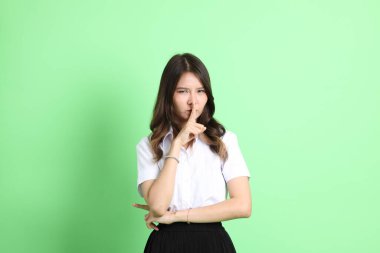 Yeşil arka planda duran üniformalı genç kız..