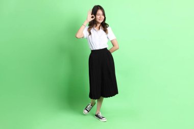 Yeşil arka planda duran üniformalı genç kız..