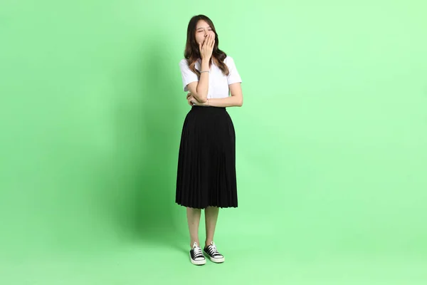 Νεαρό Κορίτσι Του Σχολείου Στολή Στέκεται Στο Πράσινο Φόντο — Φωτογραφία Αρχείου