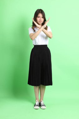 Yeşil arka planda duran üniformalı genç kız..