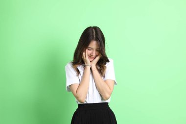 Yeşil arka planda duran üniformalı genç kız..