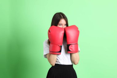 Yeşil arka planda duran üniformalı genç kız..