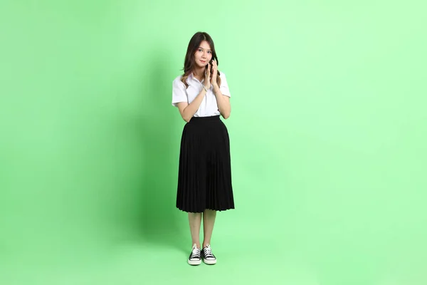 Νεαρό Κορίτσι Του Σχολείου Στολή Στέκεται Στο Πράσινο Φόντο — Φωτογραφία Αρχείου