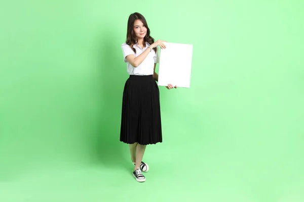 緑の背景に制服を着た若い女の子 — ストック写真