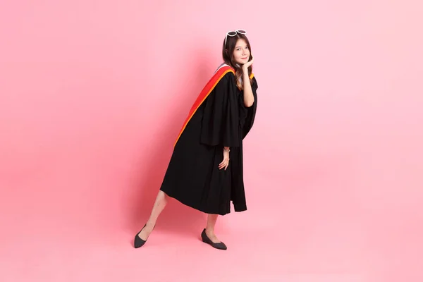 Mezuniyet Elbisesi Giymiş Pembe Arka Planda Duran Asyalı Kadın — Stok fotoğraf