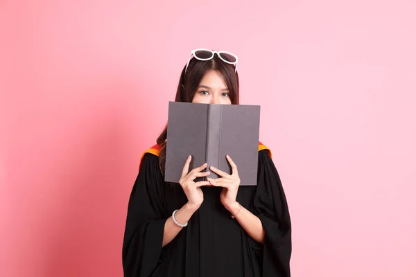 穿着毕业礼服站在粉色背景上的亚洲女人 — 图库照片
