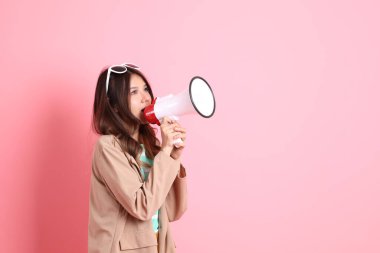 Pembe arka planda sıradan giysileri olan genç Asyalı kadın..