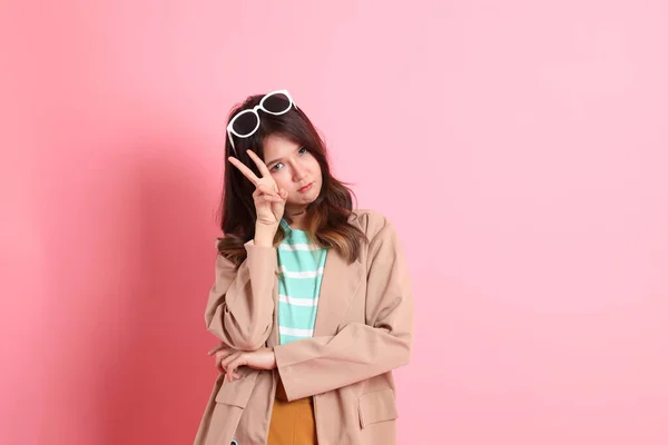 ピンクの背景にカジュアルな服を着た若い大人のアジア人女性 — ストック写真