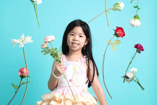 The little Asian girl with floating flower on the green background.