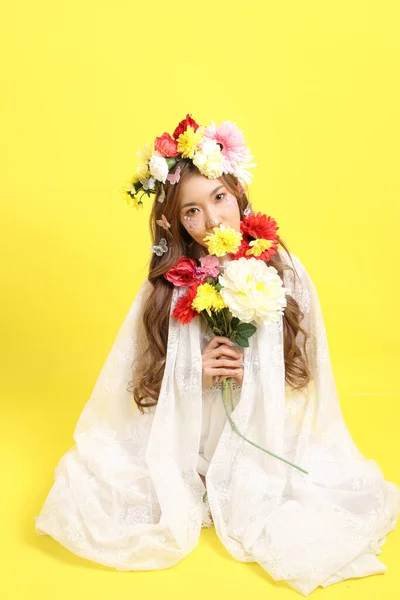 Azjatka Piękna Kobieta Kwiatem Siedzi Żółtym Tle — Zdjęcie stockowe