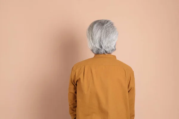 40多岁的亚洲成年人 黄色的衬衫站在棕色的背景上 — 图库照片