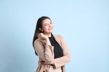 Mavi arka planda duran Asyalı iş kadını..