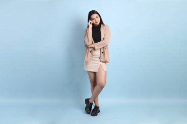 Mavi arka planda duran Asyalı iş kadını..