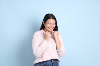 Mavi arka planda sıradan giyinmiş Asyalı kadın..