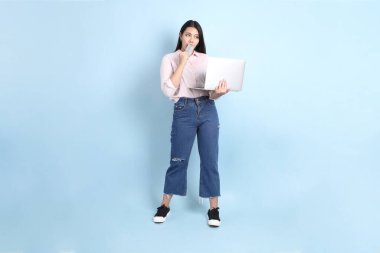 Mavi arka planda sıradan giyinmiş Asyalı kadın..