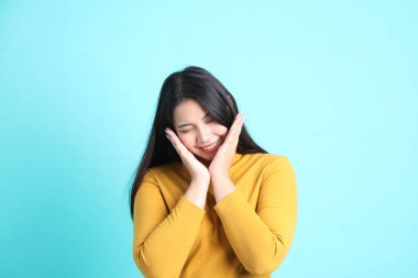 Yeşil arka planda sıradan giyinmiş Asyalı kadın..