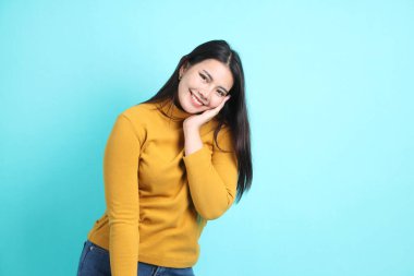 Yeşil arka planda sıradan giyinmiş Asyalı kadın..