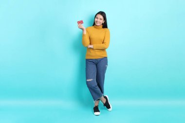 Yeşil arka planda sıradan giyinmiş Asyalı kadın..