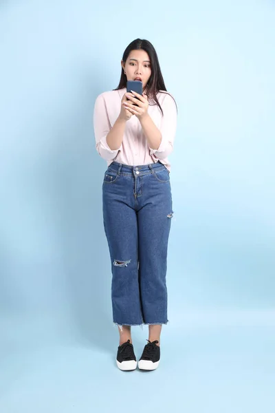 Mavi Arka Planda Sıradan Giyinmiş Asyalı Kadın — Stok fotoğraf