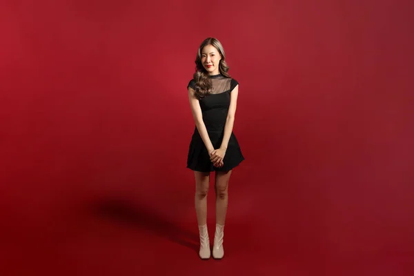 赤い背景に立っている黒い色のアジアの女性 — ストック写真