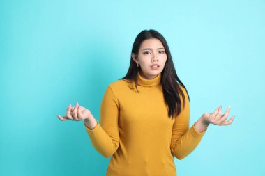 Yeşil arka planda sıradan giyinmiş Asyalı kadın..