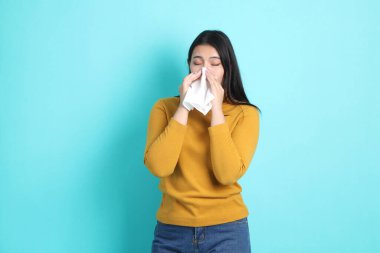 Yeşil arka planda sıradan giyinmiş Asyalı kadın..