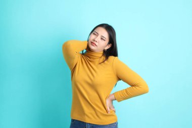 Yeşil arka planda sıradan giyinmiş Asyalı kadın..