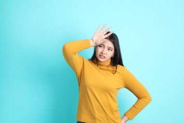 Yeşil arka planda sıradan giyinmiş Asyalı kadın..