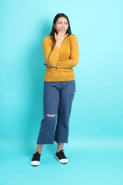 Yeşil arka planda sıradan giyinmiş Asyalı kadın..