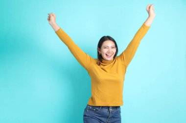 Yeşil arka planda sıradan giyinmiş Asyalı kadın..