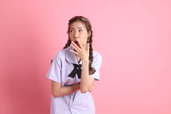 ピンクの背景に立っているタイの学生制服のアジアの少女 — ストック写真
