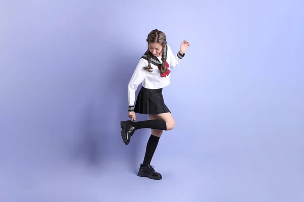 Asijky Dívka Japonské Studentské Uniformě Stojící Fialovém Pozadí — Stock fotografie